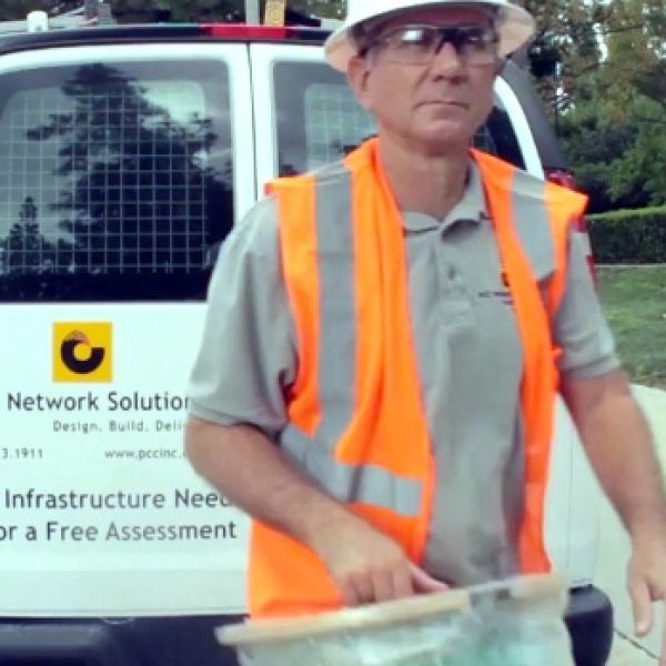 Man in orange vest working in the field.